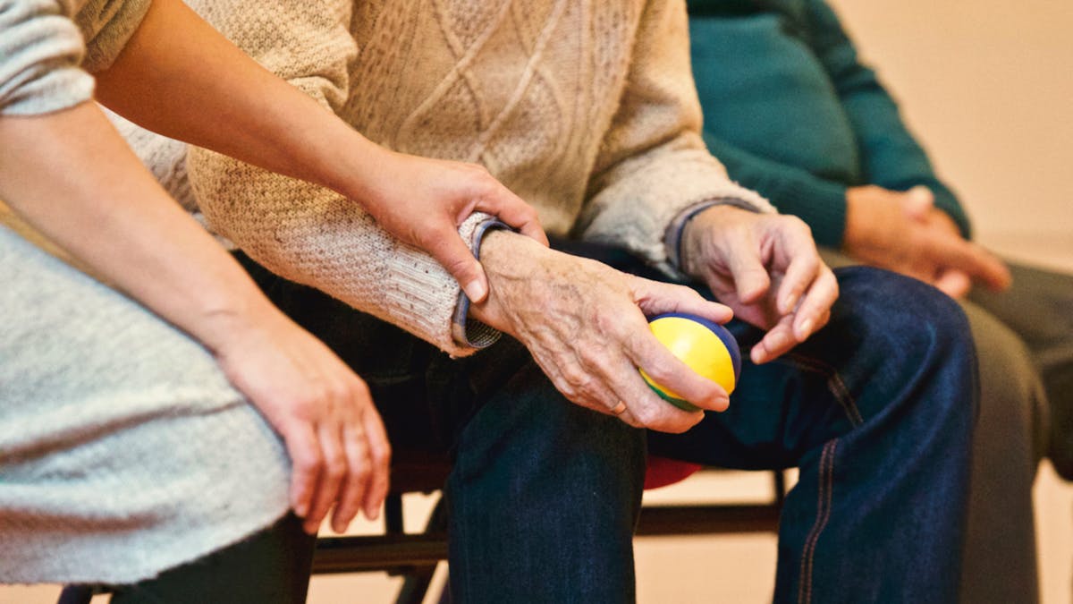 Physiotherapist helping an elderly patient with mobility exercises